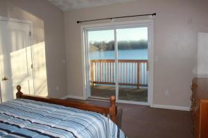 ワーウィックにあるLake Shore Houseのベッドルーム1室(ベッド1台付)、大きなスライド式ガラスドアが備わります。