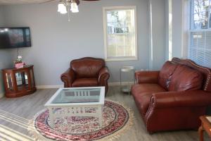 ワーウィックにあるLake Shore Houseのリビングルーム(革張りの椅子2脚、コーヒーテーブル付)
