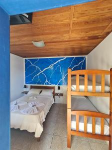 a bedroom with two beds and a bunk bed at Pousada Bicho do Mar in Arraial do Cabo