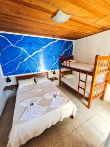 a bedroom with two twin beds and a desk at Pousada Bicho do Mar in Arraial do Cabo