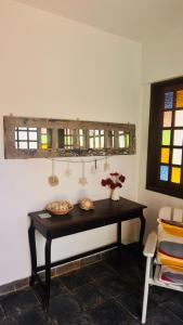 a table in the corner of a room with a window at Pousada 100 passos in Tamandaré