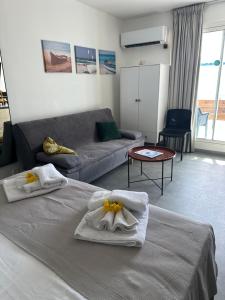 a living room with two beds and a couch at Ti Bel Soley climatisé vue mer avec réservoir d'eau in Saint-François