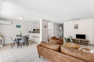 a living room with a couch and a table at Villa Sienna Hideaway 2 min walk to tramline in Gold Coast
