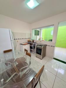 a kitchen with a glass table and chairs in it at Casa em condominio bem no centro in São Sebastião