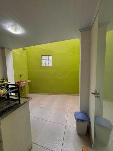 a room with a yellow wall and a toilet at Casa em condominio bem no centro in São Sebastião +14 photos