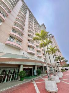 a large building with palm trees in front of it at Flat Barra Residence-3 pessoas-Fa1204-4 in Rio de Janeiro