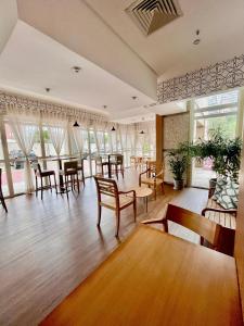 Una habitación grande con sillas, mesas y ventanas. en Flat barra residence-3 pessoas-Fa1204-4, en Río de Janeiro