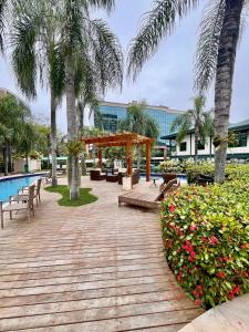 Una pasarela de madera con un pabellón junto a una piscina. en Flat barra residence-3 pessoas-Fa1204-4, en Río de Janeiro