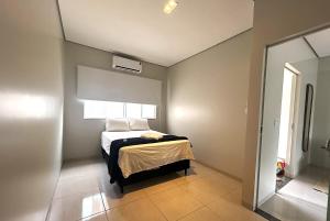 a bedroom with a bed in a room with a window at Casa 03 - Casa com 2 quartos, localizada próximo a rodoviária e aeroporto in Palmas