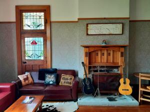 a living room with a couch and a guitar at Noah's Ark Flashpacker in Greymouth