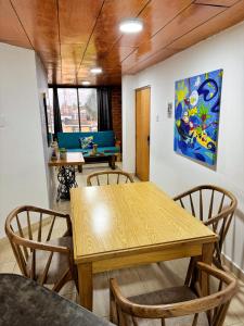 a dining room with a wooden table and chairs at Hermoso Apto Con Vista a la Basílica in Buga