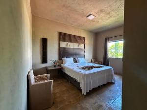 a bedroom with a bed and a chair and a window at Alfa Beach in Cacha Pregos +66 photos