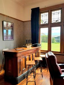 a bar in a room with chairs and a window at Noah's Ark Flashpacker in Greymouth