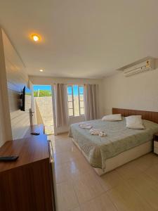 a bedroom with a bed and a television in it at Residencial Portoveleiro in Cabo Frio +93 photos