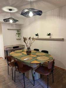 une table de salle à manger avec des chaises et un vase avec des fleurs dans l'établissement Casa Magna, à San Miguel de Tucumán