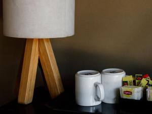 una lámpara y dos tazas de café sobre una mesa en Breeze Holiday Parks - Mary River, en Marrakai 44 fotos más