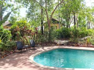 una piscina con dos sillas y una casa en Breeze Holiday Parks - Mary River, en Marrakai