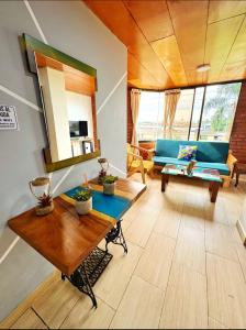 a living room with a blue couch and a table at Hermoso Apto Con Vista a la Basílica in Buga