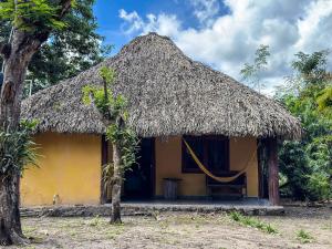 ConhuasにあるCabañas Calakmulの茅葺き屋根の小さな黄色い家