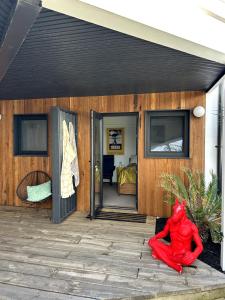 Eine rote Statue, die auf einer Terrasse vor einem Haus steht. in der Unterkunft The Coastal Cool Room in Narrabeen