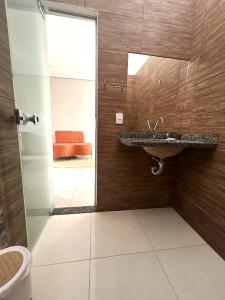 a bathroom with a sink and a toilet and a mirror at Casa 03 - Casa com 2 quartos, localizada próximo a rodoviária e aeroporto in Palmas