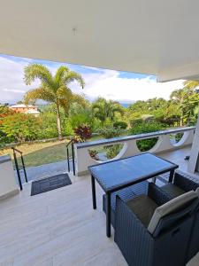 a patio with a table and chairs on a balcony at LaBelleVue Antigua Oceanview Suites and OnSite Car Rentals in Crosbies