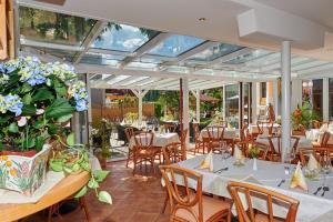 um restaurante com mesas, cadeiras e flores em Hotel Schwaiger em Eben im Pongau