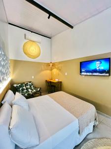 a bedroom with a bed and a tv on the wall at Pousada Nascente do Sol in Ilha de Boipeba +186 photos