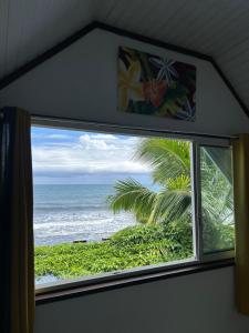 a window in a room with a view of the ocean at Ave Surfing House in Mahina