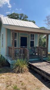 EastgateにあるLakeside Cabin for a Glamping Getaway near Tampa, Floridaの小さな青い家(ポーチとデッキ付)