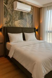 a bedroom with a large bed with white sheets at Positive Hotel in Arnavutköy