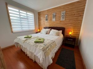 1 dormitorio con 1 cama y 2 toallas verdes en Cabañas Bell Terra Ville, en Puerto Natales