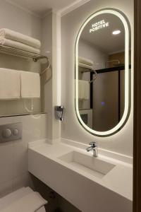 a bathroom with a sink and a mirror at Positive Hotel in Arnavutköy