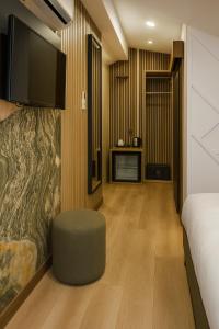 a bedroom with a bed and a chair and a tv at Positive Hotel in Arnavutköy