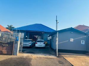a blue house with cars parked in the garage at Rose-Lee Cottage in Durban