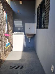 a small bathroom with a washing machine and a sink at Cantinho de aconchego 02 - com ar condicionado in Barretos