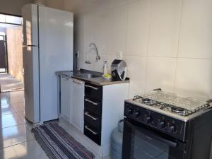 a kitchen with a stove and a refrigerator at Cantinho de aconchego 02 - com ar condicionado in Barretos +10 photos