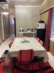 a dining room with a table and red chairs at VeKay Apartment in Mba