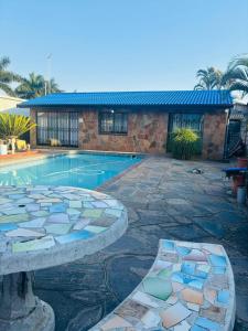 een huis met een zwembad en een gebouw bij Rose-Lee Cottage in Durban