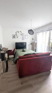 1 dormitorio con sofá rojo frente a la cama en Cocon Colombes - close to La Défense and Paris, en Colombes