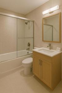 a bathroom with a toilet and a sink and a mirror at The Grand Sanken Hotel in Kalodran