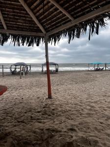 an umbrella on a beach with a view of the ocean at departamento Vacacional, frente al mar in Playas