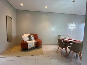 a living room with a chair and a table at Casa 03 - Casa com 2 quartos, localizada próximo a rodoviária e aeroporto in Palmas