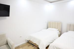 a bedroom with two beds and a couch at The Central Spot in Tirana