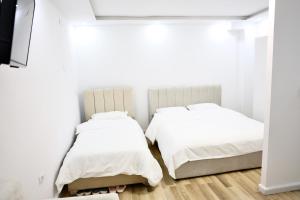a bedroom with two beds and a tv at The Central Spot in Tirana +42 photos