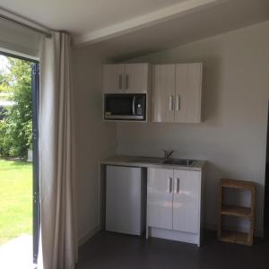 eine Küche mit Spüle und Mikrowelle in der Unterkunft The Cottage at 95a - self contained, quiet and peaceful in Big Omaha