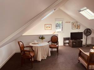 a room with a table and chairs and a tv at The Cottage at 95a - self contained, quiet and peaceful in Big Omaha