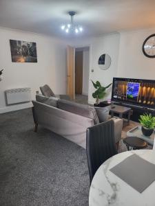 een woonkamer met een bank en een flatscreen-tv bij Enjoy city living in this one-bedroom flat, complete with a balcony and secure parking in Birmingham city center in Birmingham