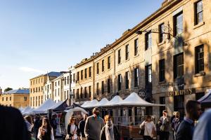 a crowd of people walking around a street with tents at Grand Old Duke in Hobart