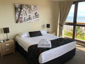 ein Schlafzimmer mit einem Bett und einem großen Fenster in der Unterkunft Coral Towers Holiday Suites in Cairns + 98 Fotos
